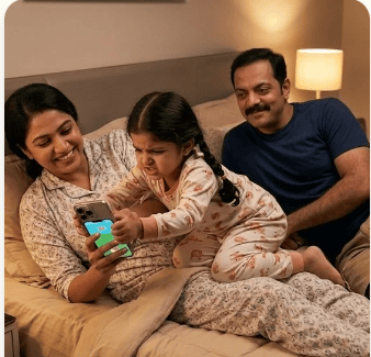 A family sitting on a bed at night, a child glued to a smartphone